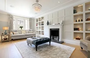 Sitting room with panelled walls, built-in shelves and a fireplace