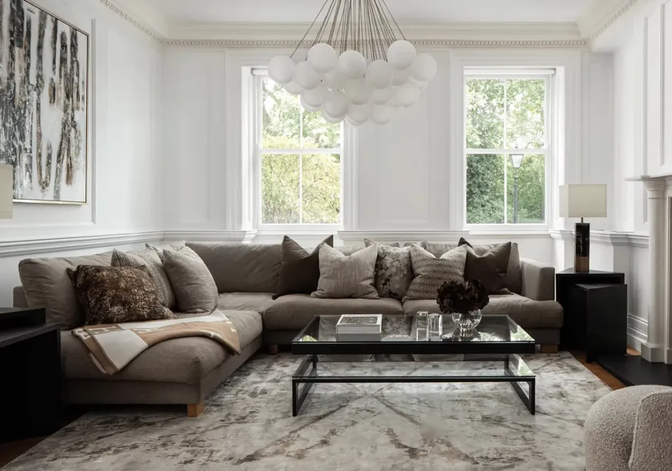 Living room with a corner sofa, glass coffee table and a cluster pendant light