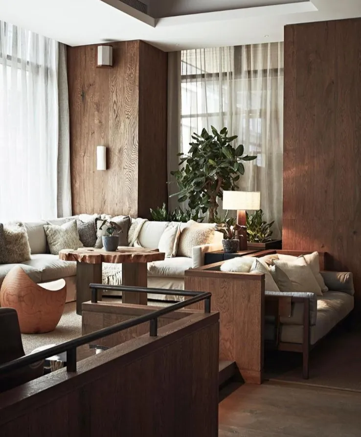 Lounge with timber-panelled walls, sofas and tall windows