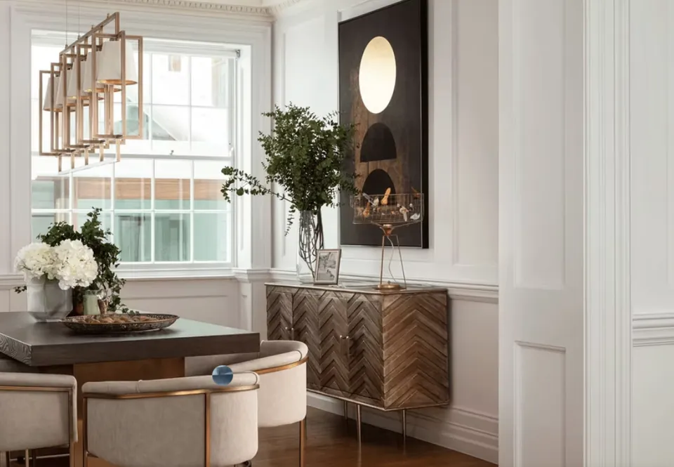 Round dining table and chairs by a tall sash window with a pendant light