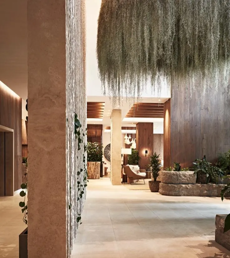 Hotel lobby with a stone floor and a hanging plant installation