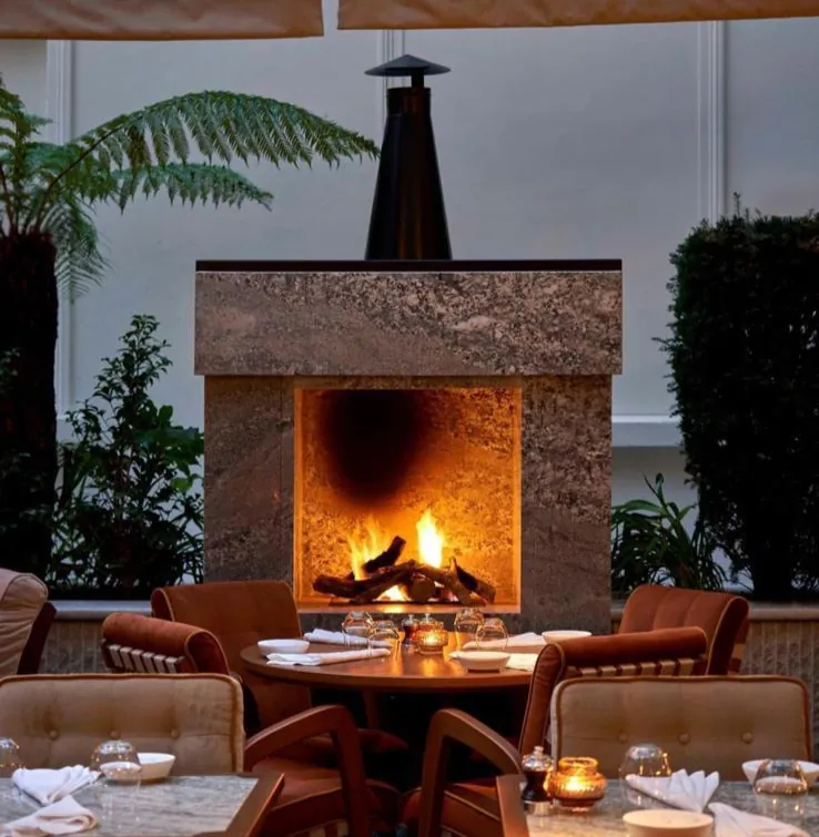 Restaurant tables arranged around an open fireplace