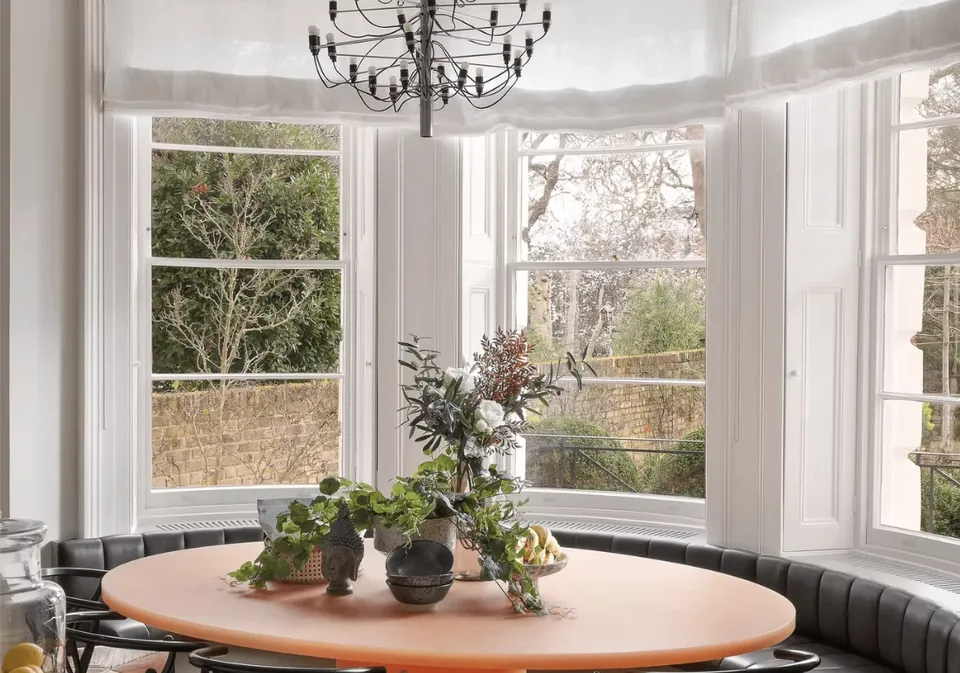 Round breakfast table with banquette seating in a bay window